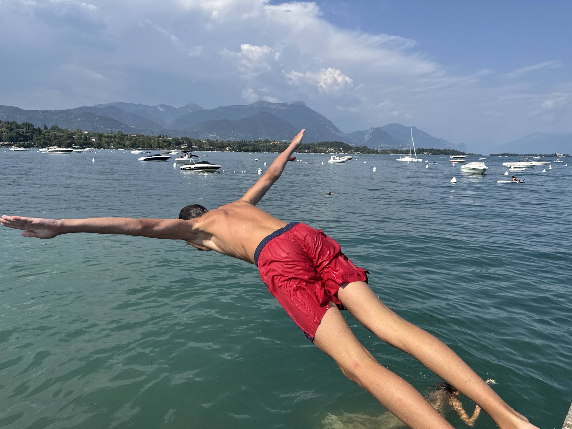 Junge springt in See vor Bergkulisse